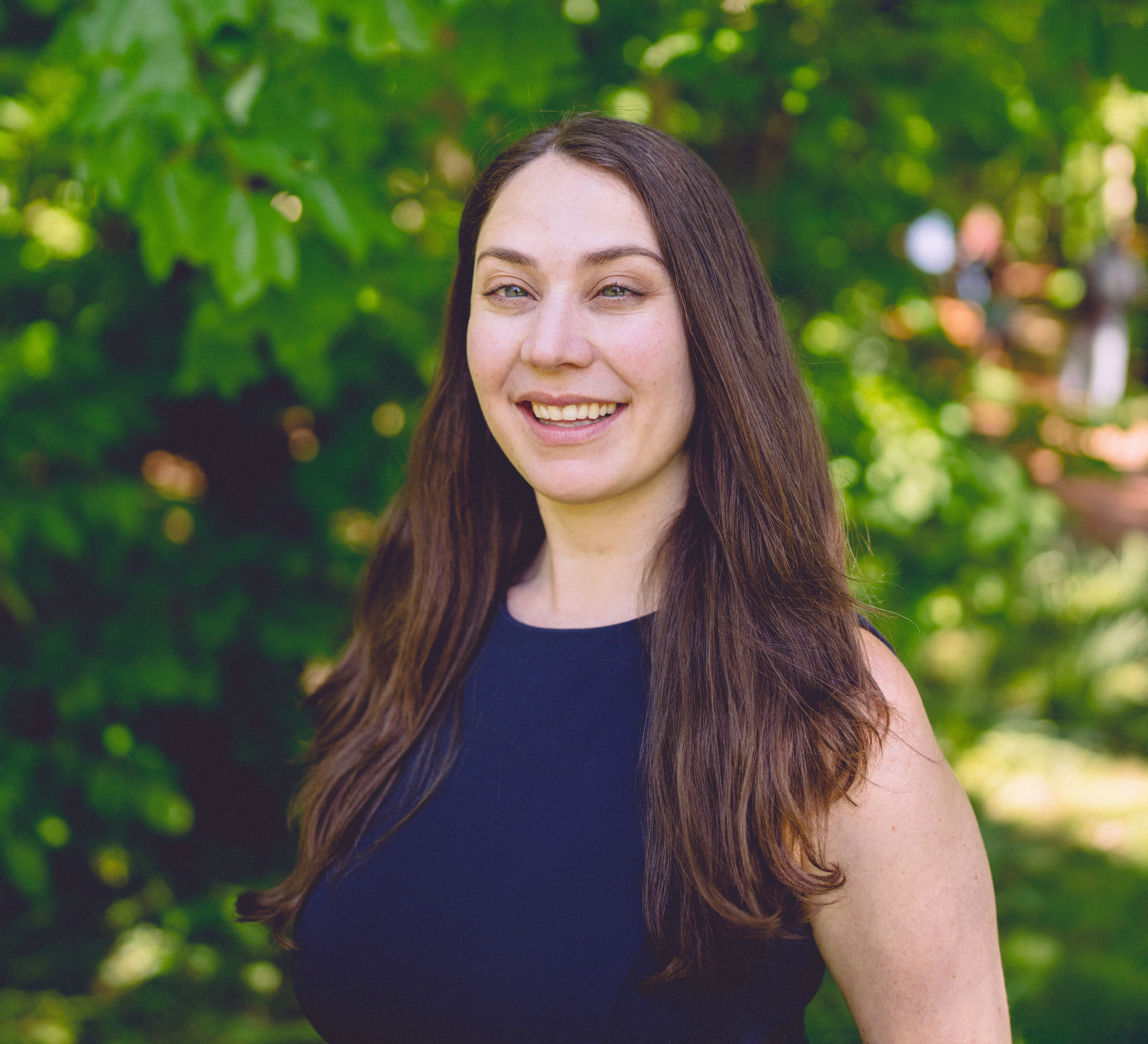 Chelsea Fenton, LMFT, a Bay Area therapist, with Kulfi her therapy dog in training, at sunset by the ocean